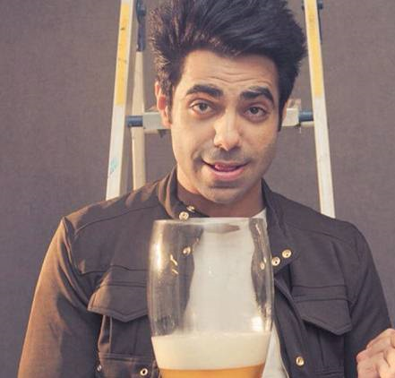 Aparshakti Khurana at a photoshoot holding a huge beer glass.